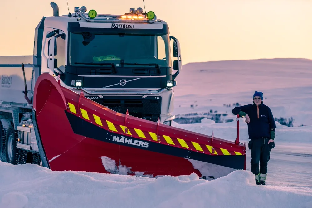 Ramlos-Volvo FH med rød og gul Mählers-plog, maskinfører lener seg mot plogbladet