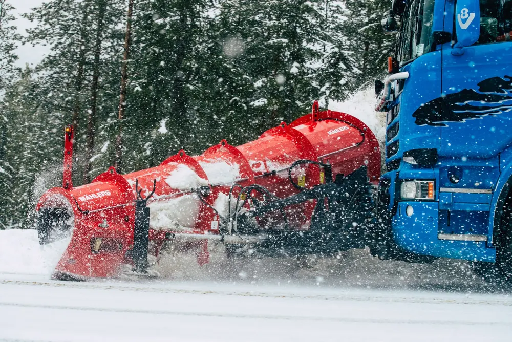 Rød Mählers snøfreser montert på blå Kyllo Maskin-lastebil i snøfall